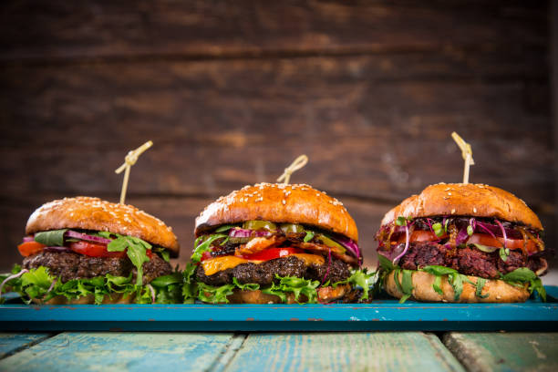 istock Tasty burgers on wooden table 859863686