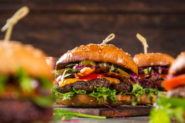 istock Tasty burgers on wooden table 859865176