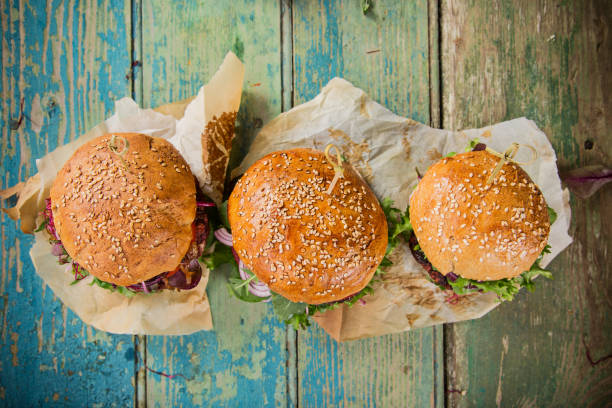 istock Tasty burgers on wooden table 859870832