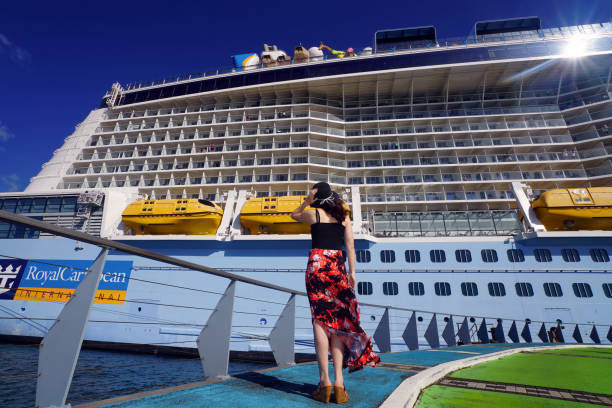Woman Looking at a Cruise Ship Fort-de-France, Martinique - April 23, 2017: On Pier, a woman is looking at Anthem of the Seas cruise ship. french overseas territory photos stock pictures, royalty-free photos & images