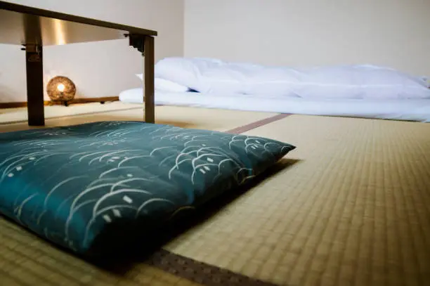 Traditional Japanese Ryokan room with tatimi mats and futon, pillow and table, Japan