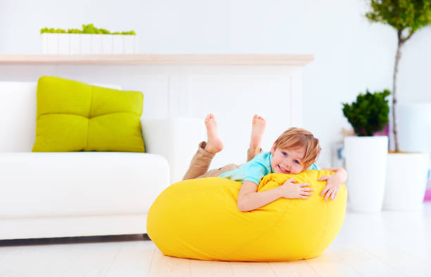 istock excited kid having fun on yellow bean bag at home 859875856