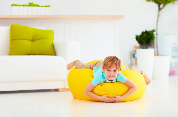 istock excited kid having fun on yellow bean bag at home 859875900