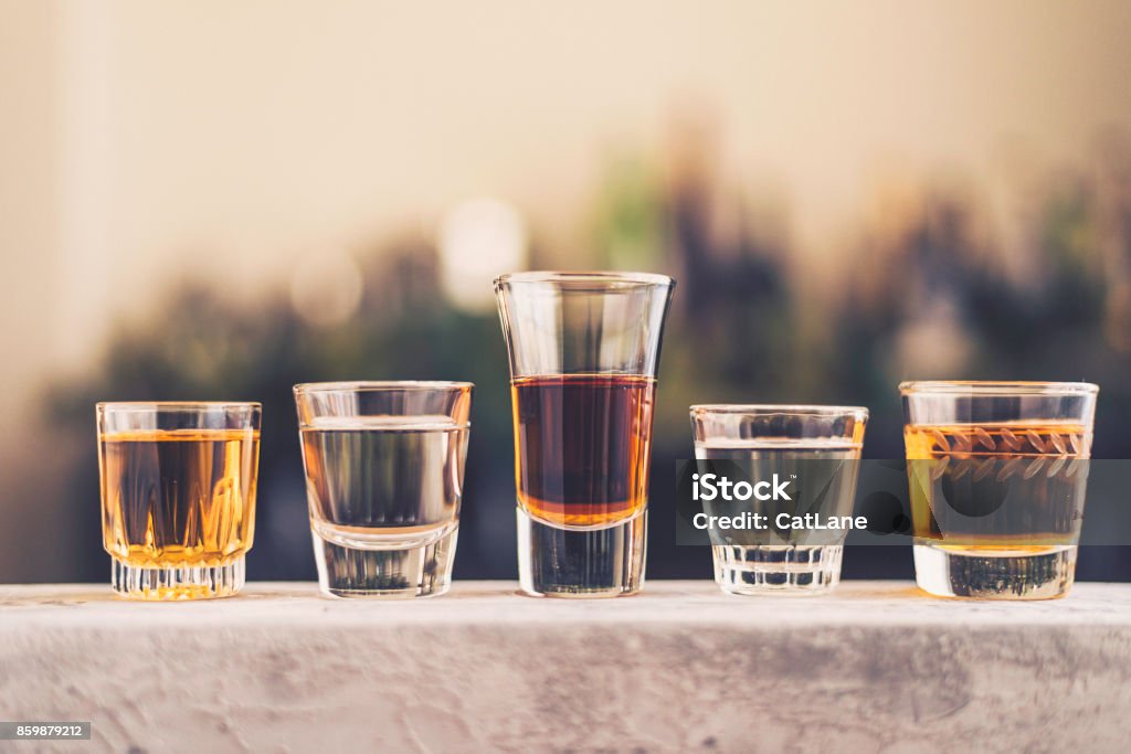 Five shot glasses filled with a variety of alcohol Tequila - Drink Stock Photo