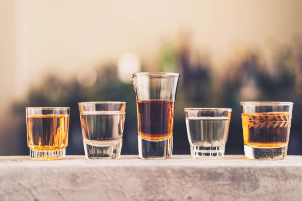 five shot glasses filled with a variety of alcohol - shot glass imagens e fotografias de stock