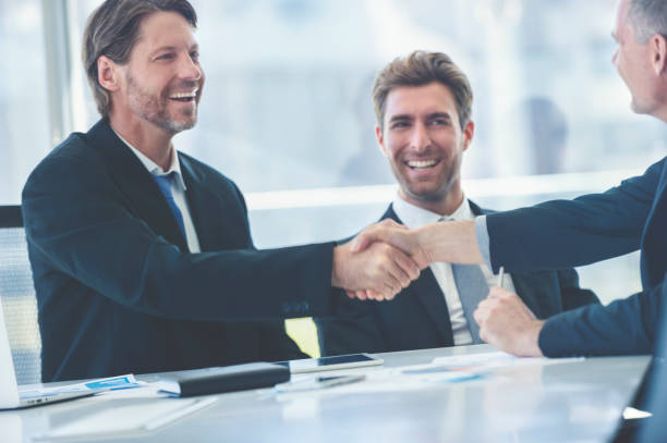 istock Businessmen shaking hands at the board room table. 859896838