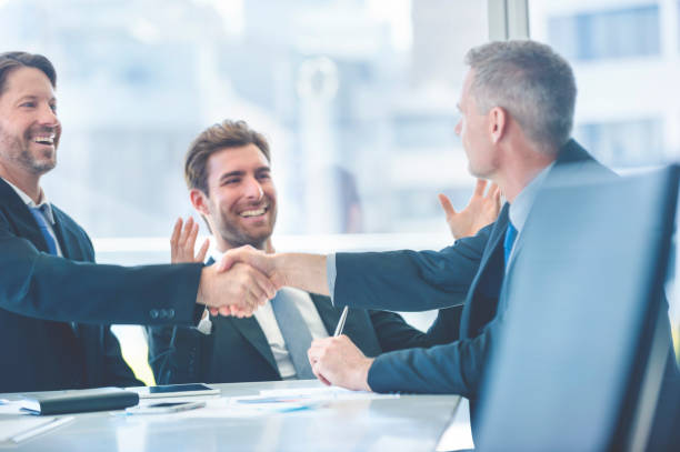 istock Businessmen shaking hands at the board room table. 859896840