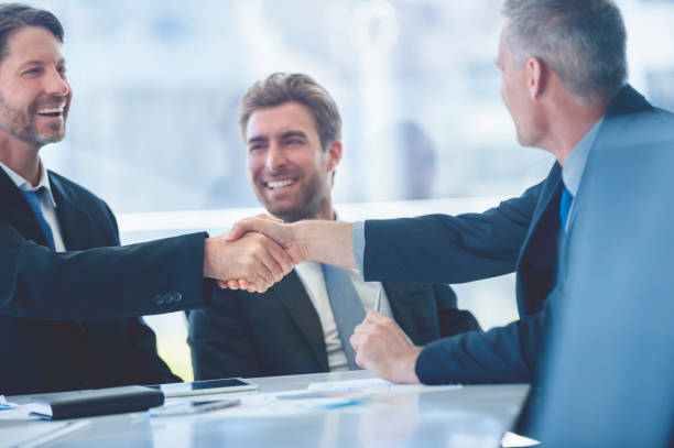 istock Businessmen shaking hands at the board room table. 859896842