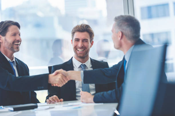 istock Businessmen shaking hands at the board room table. 859896848