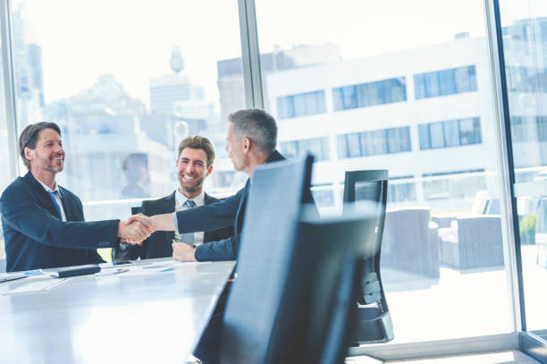 istock Businessmen shaking hands at the board room table. 859896850