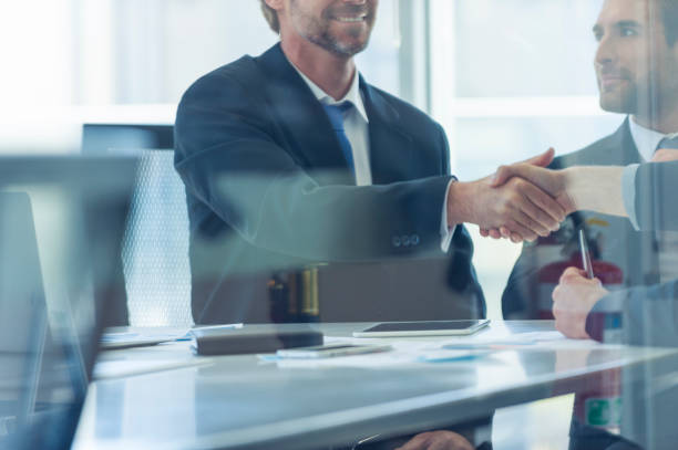 istock Businessmen shaking hands at the board room table. 859896862