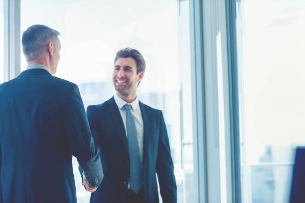 istock Mature and young businessmen shaking hands. 859905138