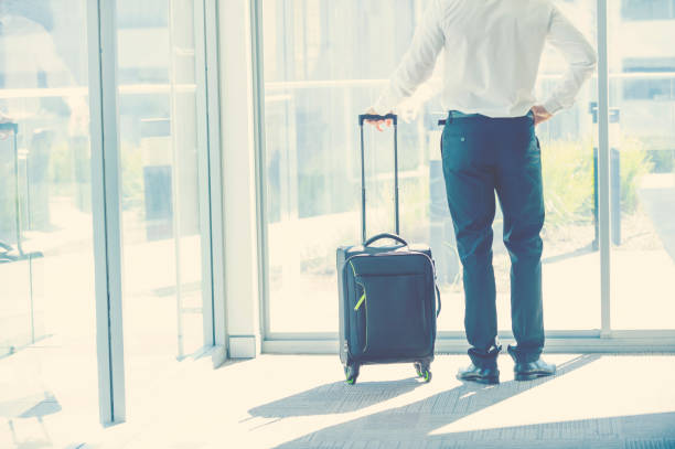 istock Businessman waiting at airport with a suitcase 859905146
