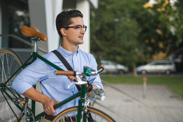 istock Handsome young businessman carrying bicycle 859915998