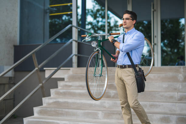 istock Handsome young businessman carrying bicycle 859916028