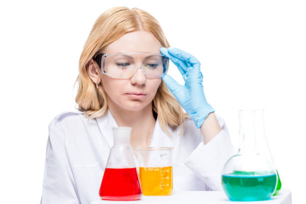 istock Chemist corrects his glasses, looks at the multicolored test tubes on the desktop 859918380