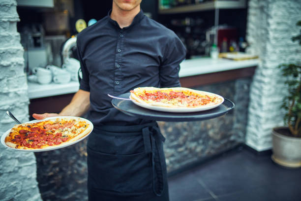 istock Waiters carrying plates with food, in a restaurant. 859926120
