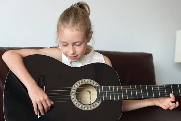 istock Little girl learns to play guitar. 859929316