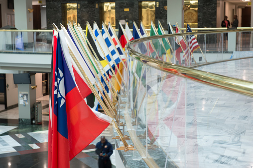 Atlanta, USA - September 15, 2017. Flag display at atrium inside the Atlanta City Hall with people walking under or at standing at the hallway. The city hall is located on Mitchell St SW in downtown Atlanta and serves as the headquarters of Atlanta municipal government.