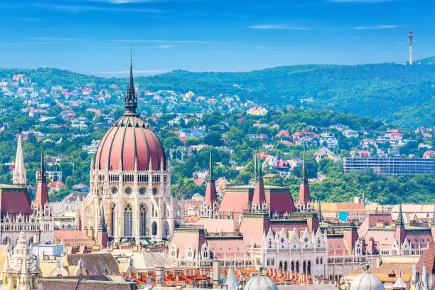 Travel and european tourism concept. Parliament and buda side panorama of Budapest in Hungary during summer sunny day with blue sky and clouds. View from Saint Istvan's basil