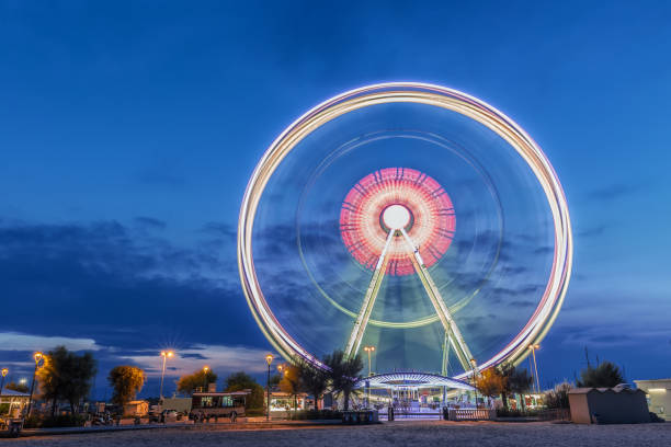 ruota panoramica rotante all'alba ora blu a rimini, italia. immagine astratta a lunga esposizione - rimini foto e immagini stock