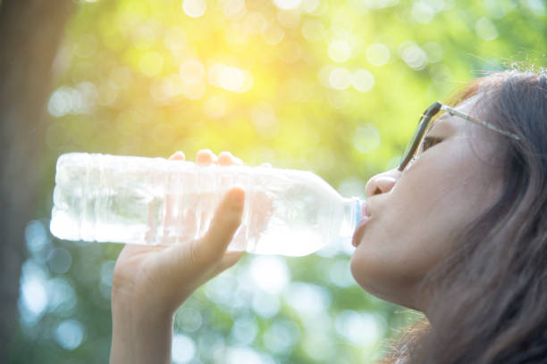 istock beautiful girl drinks water from a bottle on the nature 859931288