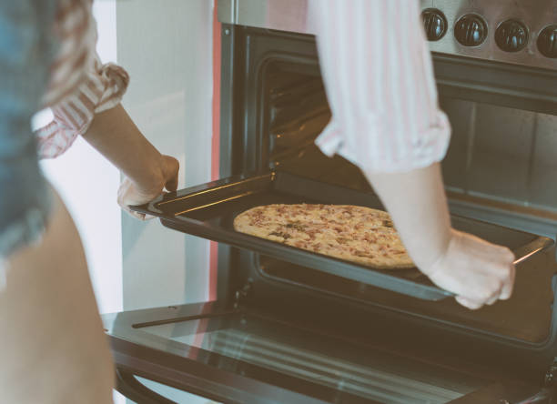 istock Woman preparing pizza bought in a store. 859932616