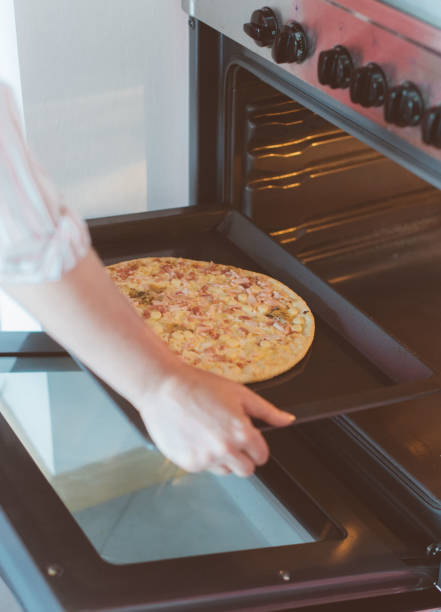 istock Woman preparing pizza bought in a store. 859932630