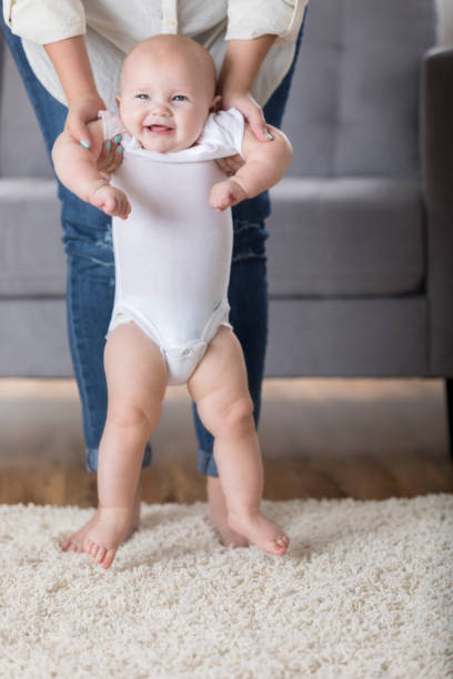 istock Mom helps baby walk 859936580