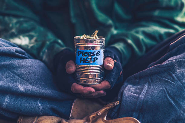 istock Fighting adversity. Homeless man holding money tin 859943200