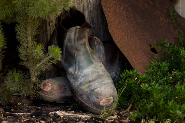 istock old workboots resting against wooden fence post 859944114