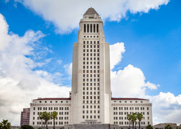 Los Angeles City Hall looking up at the central tower’s west facing facade, with a blue sky and white cumulus clouds.