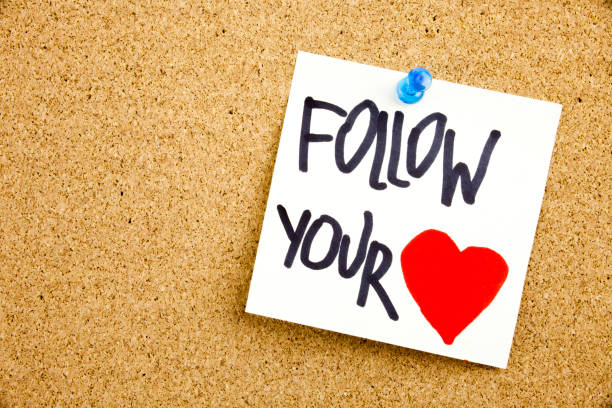 istock A yellow sticky note writing, caption, inscription Phrase FOLLOW YOUR HEART in black ext on a sticky note pinned to a cork notice board 859955966
