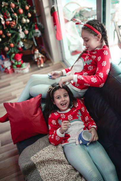 istock Two Smiling Little Sisters Lying on Sofa and Eating Chocolate 859956284