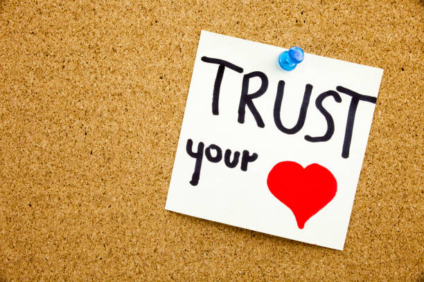 istock A yellow sticky note writing, caption, inscription Phrase TRUST YOUR HEART in black ext on a sticky note pinned to a cork notice board 859956490