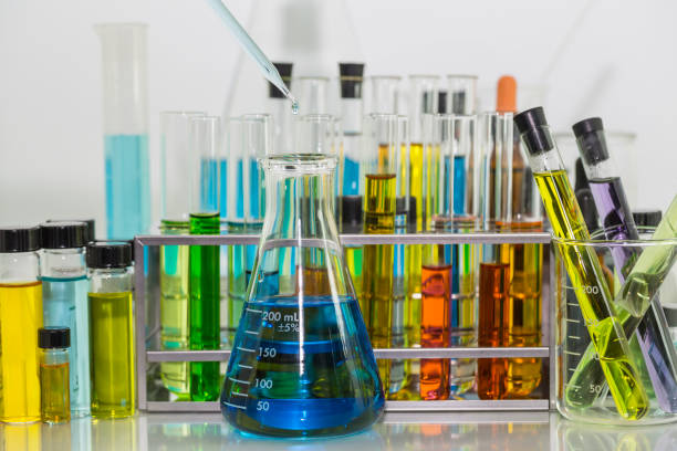 istock Pipette dropping over the blue chemical solution in Erlenmeyer flask and test tubes with colorful chemical solution in test tubes rack on the table 859959960