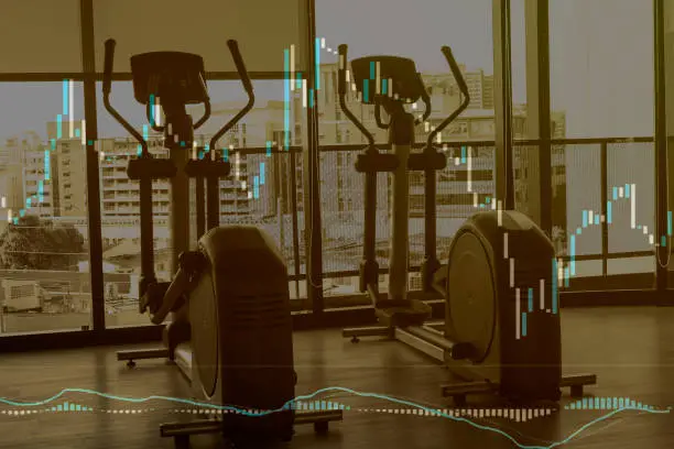 Photo of Rows of dumbbells in the fitness center gym in hign contrast with monochrome color tones and greys with heart rate graph