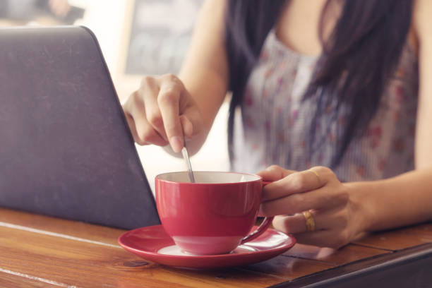 istock young woman drinking hot coffee in cafe and working. 859968150