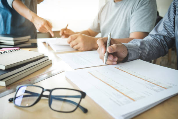 istock Education, teaching, learning and people concept. Group of high school students or classmates with helps friend catching up workbook learning in classroom, Tutor books with friends 859975880