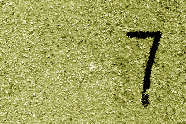 istock Number seven on yellow grungy cement wall. 859978756