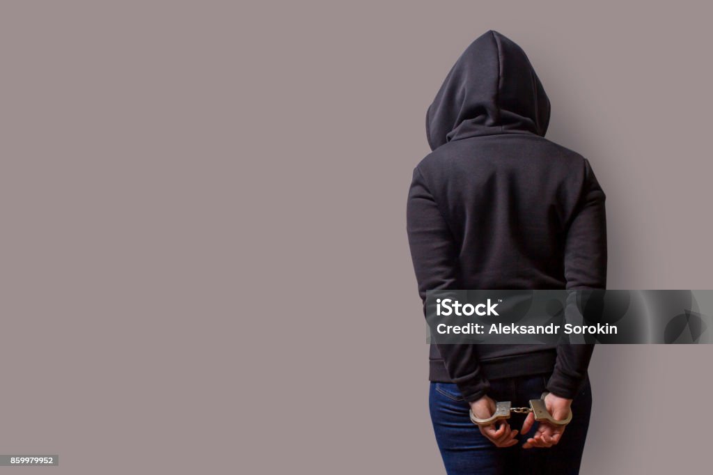 vista trasera de una niña en una capilla del negro con manos esposadas aislado sobre un fondo gris - Foto de stock de Espalda - Partes del cuerpo libre de derechos
