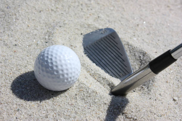 istock Golf ball in a sand bunker  Sandwedge golf club 859983952