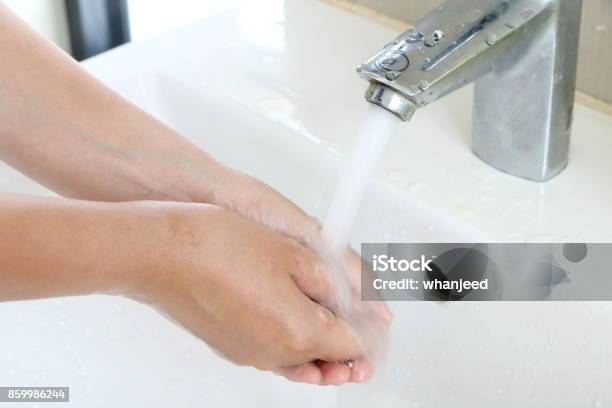 The Woman Cleaning Dirty Hands By Washing Hand With Foam Soap And Water In White Sink In Bathroom Stock Photo - Download Image Now