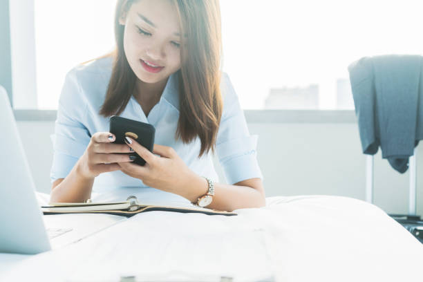 istock young business woman texting on cellphone in room 859986418