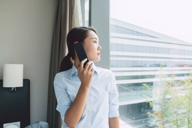 istock beautiful business woman talking on phone by window 859987764