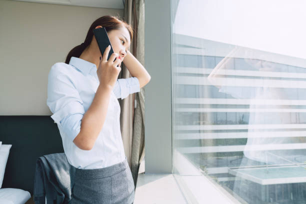 istock beautiful business woman talking on phone by window 859987772