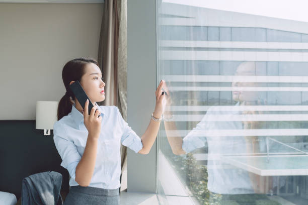 istock beautiful business woman talking on phone by window 859987826