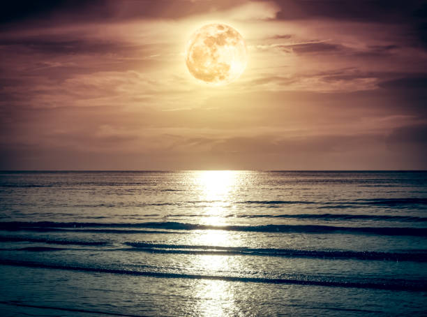 istock Colorful sky with dark cloud and bright full moon over seascape. 859996322
