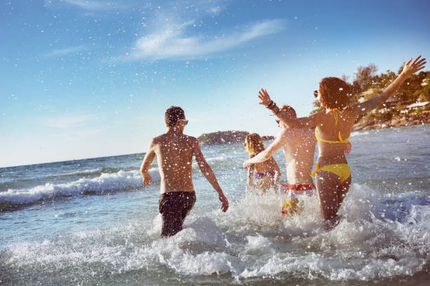 幸せな友人の海のビーチの休日 - beach men party bikini ストックフォトと画像