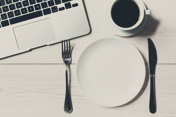 istock Business or diet concept, workplace with laptop and empty plate 859997344